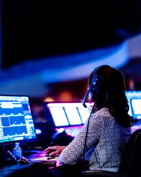 Seseorang dengan headset memantau beberapa layar